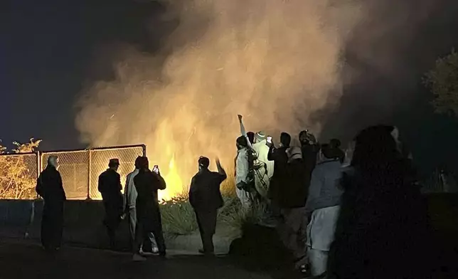 Supporters of imprisoned former premier Imran Khan's Pakistan Tehreek-e-Insaf party, burn bushes to reduce the impact of tear gas shells fired by police officers to disperse them during a rally demanding Khan's release, at a motorway in Ghazi in Attock district, Pakistan, Sunday, Nov. 24, 2024. (AP Photo/Maaz Awan)