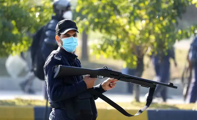 A police officer loads his riffle with rubber bullets during clashes with supporters of imprisoned former Premier Imran Khan's Pakistan Tehreek-e-Insaf party, in Islamabad, Pakistan, Tuesday, Nov. 26, 2024. (AP Photo/Anjum Naveed)
