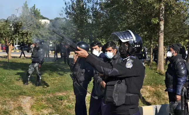A police officer fires a rubber bullet during clashes with supporters of imprisoned former Premier Imran Khan's Pakistan Tehreek-e-Insaf party, in Islamabad, Pakistan, Tuesday, Nov. 26, 2024. (AP Photo/Anjum Naveed)