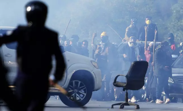 Supporters of imprisoned former Premier Imran Khan's Pakistan Tehreek-e-Insaf party throw stones toward police during clashes in Islamabad, Pakistan, Tuesday, Nov. 26, 2024. (AP Photo/Anjum Naveed)
