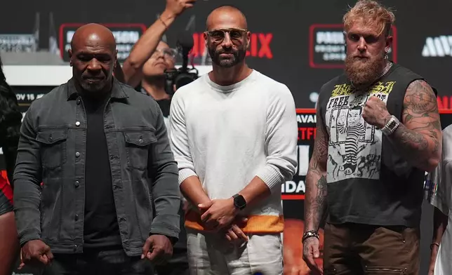 Mike Tyson, left, and Jake Paul, right, pose for photographs during a news conference ahead of their fight, Wednesday, Nov. 13, 2024, in Irving, Texas. (AP Photo/Julio Cortez)