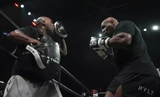 Mike Tyson, right, works out ahead of his boxing match against Jake Paul, Tuesday, Nov. 12, 2024, in Irving, Texas. (AP Photo/Julio Cortez)