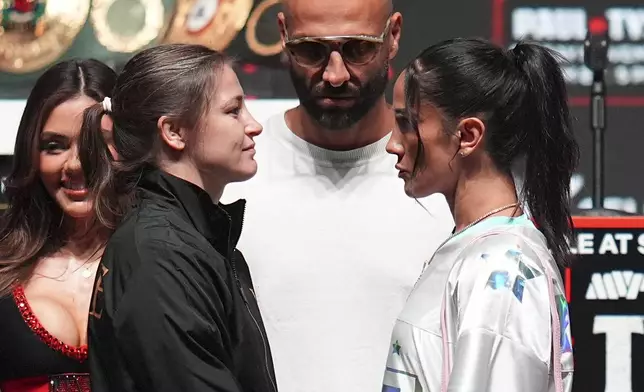 Katie Taylor, front left, and Amanda Serrano, front right, face off during a news conference ahead of her undisputed super lightweight world title bout, the co-main event in the Mike Tyson vs. Jake Paul fight night, Wednesday, Nov. 13, 2024, in Irving, Texas. (AP Photo/Julio Cortez)