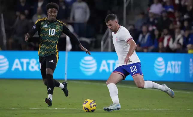 United States' Joe Scally (22) passes around Jamaica's Demarai Gray (10) during the first half in a CONCACAF Nations League quarterfinal second leg soccer match Monday, Nov. 18, 2024, in St. Louis. (AP Photo/Jeff Roberson)