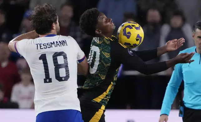 Jamaica's Demarai Gray and United States' Tanner Tessmann (18) battle for the ball during the first half in a CONCACAF Nations League quarterfinal second leg soccer match Monday, Nov. 18, 2024, in St. Louis. (AP Photo/Jeff Roberson)