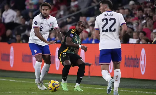 Jamaica's Amari'i Bell passes between United States' Weston McKennie (8) and Joe Scally (22) during the first half in a CONCACAF Nations League quarterfinal second leg soccer match Monday, Nov. 18, 2024, in St. Louis. (AP Photo/Jeff Roberson)