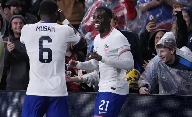 United States' Tim Weah, right, is congratulated by teammate Yunus Musah (6) after scoring during the second half in a CONCACAF Nations League quarterfinal second leg soccer match against Jamaica Monday, Nov. 18, 2024, in St. Louis. (AP Photo/Jeff Roberson)