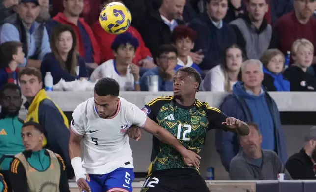 Jamaica's Tayvon Gray (12) and United States' Ricardo Pepi (9) battle for the ball during the first half in a CONCACAF Nations League quarterfinal second leg soccer match Monday, Nov. 18, 2024, in St. Louis. (AP Photo/Jeff Roberson)