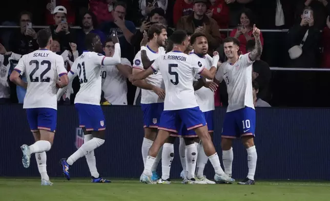 United States' Christian Pulisic, right, is congratulated by teammates after scoring during the first half in a CONCACAF Nations League quarterfinal second leg soccer match against Jamaica Monday, Nov. 18, 2024, in St. Louis. (AP Photo/Jeff Roberson)