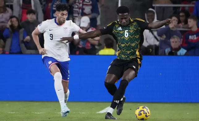 Jamaica's Di'Shon Bernard (6) and United States' Ricardo Pepi (9) chase after a loose ball during the first half in a CONCACAF Nations League quarterfinal second leg soccer match Monday, Nov. 18, 2024, in St. Louis. (AP Photo/Jeff Roberson)