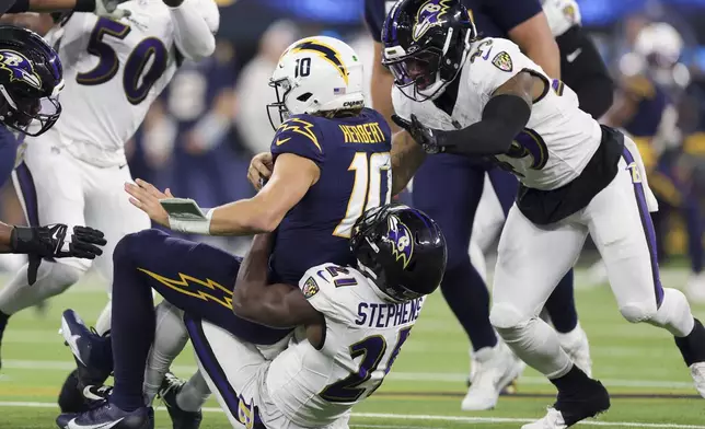 Baltimore Ravens cornerback Brandon Stephens (21) sacks Los Angeles Chargers quarterback Justin Herbert (10) during the second half of an NFL football game Monday, Nov. 25, 2024, in Inglewood, Calif. (AP Photo/Ryan Sun)