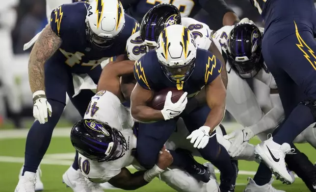 Los Angeles Chargers running back J.K. Dobbins (27) is tackled by Baltimore Ravens linebacker Malik Harrison (40) during the first half of an NFL football game Monday, Nov. 25, 2024, in Inglewood, Calif. (AP Photo/Eric Thayer)