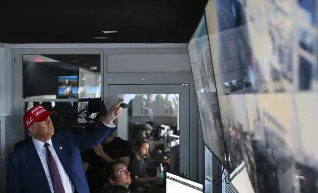 President-elect Donald Trump speaks as Elon Musk explains the operations in the control room ahead of the launch of the sixth test flight of the SpaceX Starship rocket Tuesday, Nov. 19, 2024 in Brownsville, Texas. (Brandon Bell/Pool via AP)