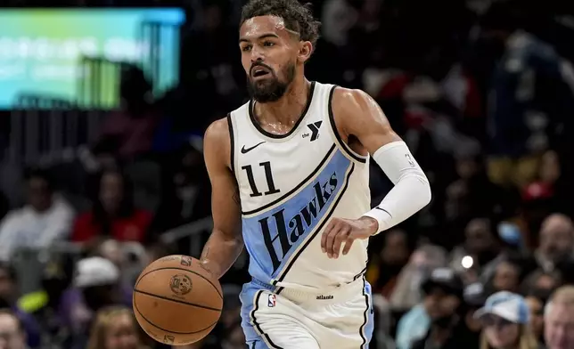 Atlanta Hawks guard Trae Young (11) moves the ball up court against the Dallas Mavericks during the first half of an NBA basketball game, Monday, Nov. 25, 2024, in Atlanta. (AP Photo/Mike Stewart)