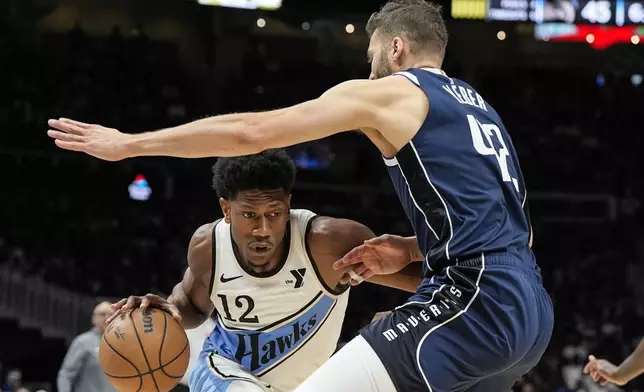 Atlanta Hawks forward De'Andre Hunter (12) moves against Dallas Mavericks forward Maxi Kleber (42) during the first half of an NBA basketball game, Monday, Nov. 25, 2024, in Atlanta. (AP Photo/Mike Stewart)