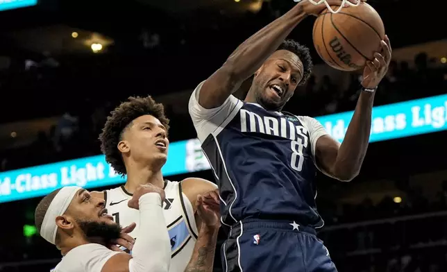 Dallas Mavericks forward Olivier-Maxence Prosper (8) takes the ball from Atlanta Hawks forward Jalen Johnson (1) during the first half of an NBA basketball game, Monday, Nov. 25, 2024, in Atlanta. (AP Photo/Mike Stewart)