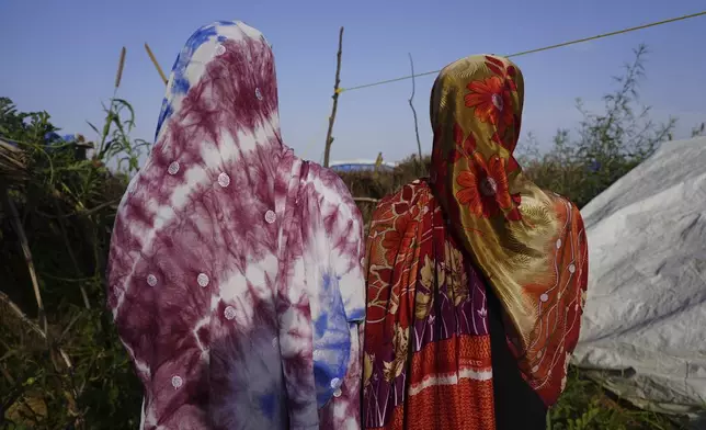 Women who fled war in Sudan and requested anonymity because they feared retribution after reporting sexual exploitation, walk in a refugee camp in Adre, Chad, Saturday, Oct. 5, 2024. (AP Photo/Sam Mednick)