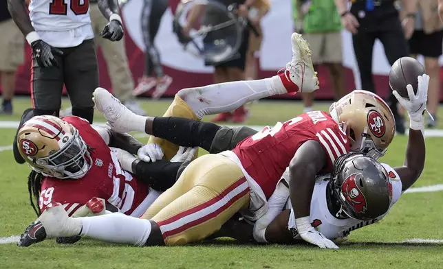 Tampa Bay Buccaneers running back Rachaad White, bottom right, reacts after scoring a touchdown against San Francisco 49ers linebacker De'Vondre Campbell, bottom left, and safety Malik Mustapha during the second half of an NFL football game in Tampa, Fla., Sunday, Nov. 10, 2024. (AP Photo/Chris O'Meara)