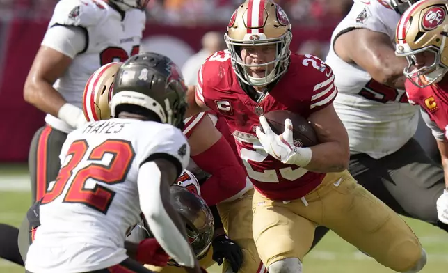 San Francisco 49ers running back Christian McCaffrey, right, runs against Tampa Bay Buccaneers safety Josh Hayes (32) during the second half of an NFL football game in Tampa, Fla., Sunday, Nov. 10, 2024. (AP Photo/Chris O'Meara)