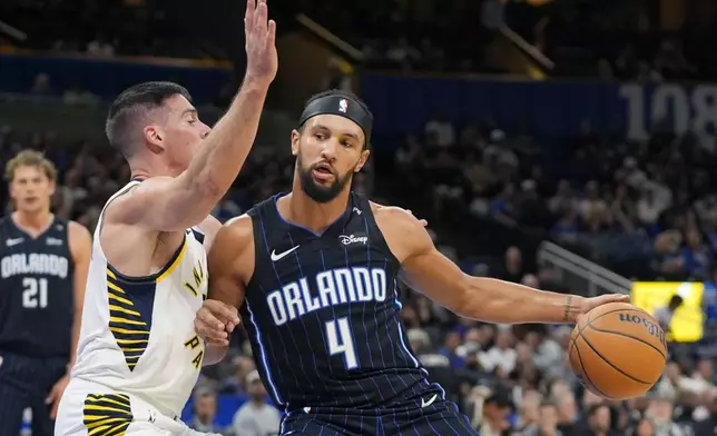 Orlando Magic guard Jalen Suggs (4) makes a move against Indiana Pacers guard T.J. McConnell, left, during the first half of an NBA basketball game, Wednesday, Nov. 13, 2024, in Orlando, Fla. (AP Photo/John Raoux)