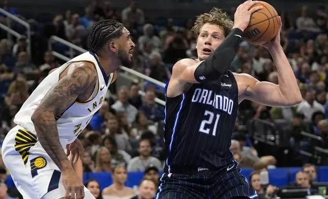 Orlando Magic center Moritz Wagner (21) looks for a shot against Indiana Pacers forward Obi Toppin, left, during the first half of an NBA basketball game, Wednesday, Nov. 13, 2024, in Orlando, Fla. (AP Photo/John Raoux)