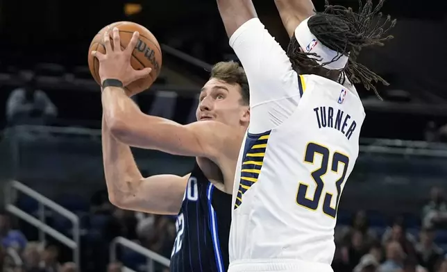 Orlando Magic forward Franz Wagner, left, goes up for a shot against Indiana Pacers center Myles Turner (33) during the first half of an NBA basketball game, Wednesday, Nov. 13, 2024, in Orlando, Fla. (AP Photo/John Raoux)