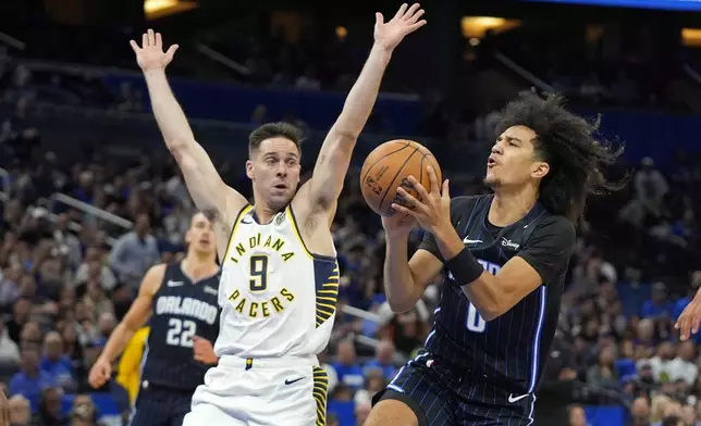 Orlando Magic guard Anthony Black, right, takes a shot as Indiana Pacers guard T.J. McConnell (9) defends during the first half of an NBA basketball game, Wednesday, Nov. 13, 2024, in Orlando, Fla. (AP Photo/John Raoux)