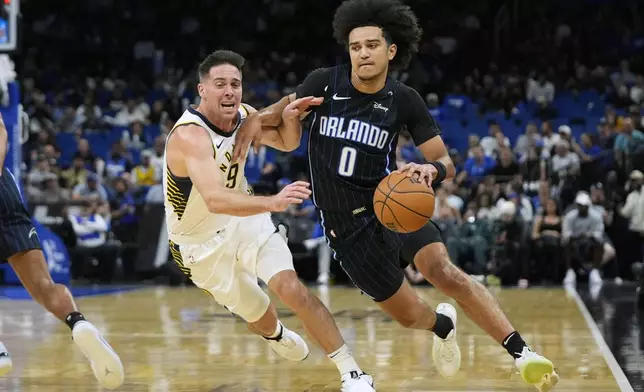 Orlando Magic guard Anthony Black (0) drives against Indiana Pacers guard T.J. McConnell, right, during the first half of an NBA basketball game, Wednesday, Nov. 13, 2024, in Orlando, Fla. (AP Photo/John Raoux)