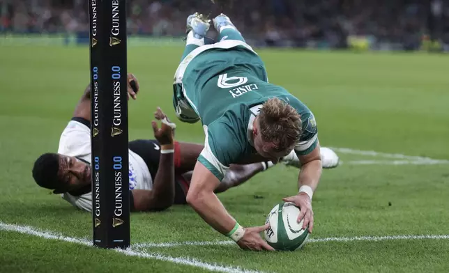 Ireland's Craig Casey, right, scores his try during the Autumn Nations Series rugby union match between Ireland and Fiji, at Aviva Stadium, Dublin, Ireland, Saturday, Nov. 23, 2024. (AP Photo/Peter Morrison)