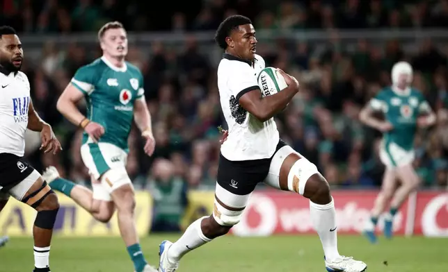 Fiji's Setareki Turagacoke, right, breaks through to score his try during the Autumn Nations Series rugby union match between Ireland and Fiji, at Aviva Stadium, Dublin, Ireland, Saturday, Nov. 23, 2024. (AP Photo/Peter Morrison)