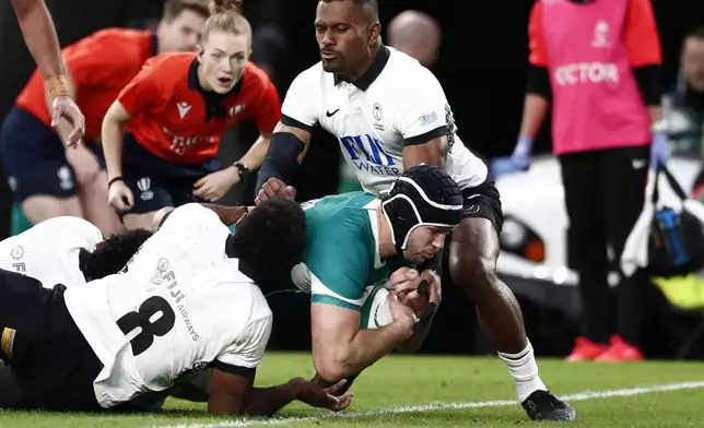 Ireland's captain Caelan Doris, bottom right, scores a try during the Autumn Nations Series rugby union match between Ireland and Fiji, at Aviva Stadium, Dublin, Ireland, Saturday, Nov. 23, 2024. (AP Photo/Peter Morrison)