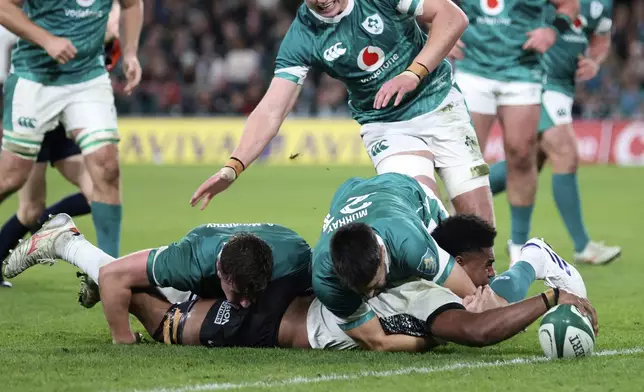 Fiji's Kitione Salawa, right, scores his try during the Autumn Nations Series rugby union match between Ireland and Fiji, at Aviva Stadium, Dublin, Ireland, Saturday, Nov. 23, 2024. (AP Photo/Peter Morrison)