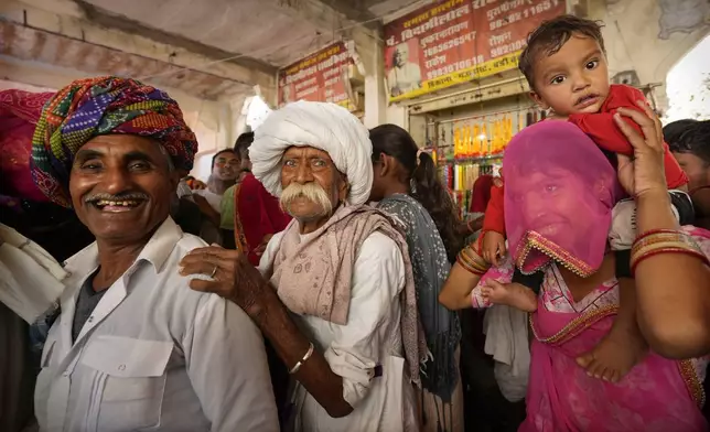 Villagers arrive to take a dip in the Pushkar lake, considered sacred by Hindus, during a camel fair in Pushkar, in the northwestern Indian state of Rajasthan, Tuesday, Nov. 12, 2024. (AP Photo/Deepak Sharma)