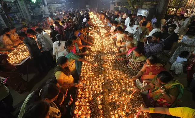 Hindu devotees light earthen lamps at a temple on auspicious day of Karthik Purnima, which is celebrated on full moon day of the Hindu calendar month "Karthika", in Hyderabad, India, Friday, Nov. 15, 2024. (AP Photo/Mahesh Kumar A.)