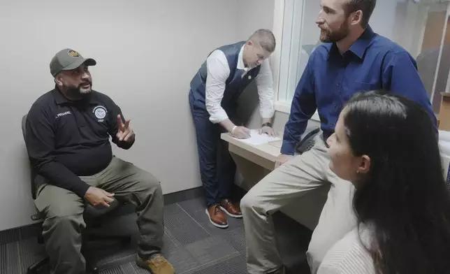 Federal Wildlife Officer Cody Smith and Border Patrol processing coordinator Yaira Santiago listen to Border Patrol agent Andry Fernandez during a training scenario where they practice their new chaplain skills, Wednesday, Nov. 20, 2024, in Dania Beach, Fla. (AP Photo/Marta Lavandier)