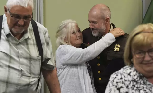 U.S. Fish and Wildlife law enforcement agent is surrounded by his family following the Border Patrol Chaplain Academy graduation, Thursday, Nov. 21, 2024, in Dania Beach, Fla. (AP Photo/Marta Lavandier)