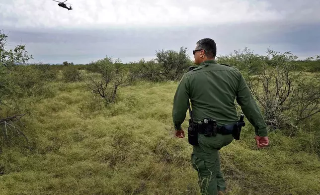 U.S. Border Patrol agent Jesus Vasavilbaso, aided by a Black Hawk helicopter, searches for a group of migrants evading capture in the desert brush at the base of the Baboquivari Mountains, Thursday, Sept. 8, 2022, near Sasabe, Ariz. (AP Photo/Matt York, File)