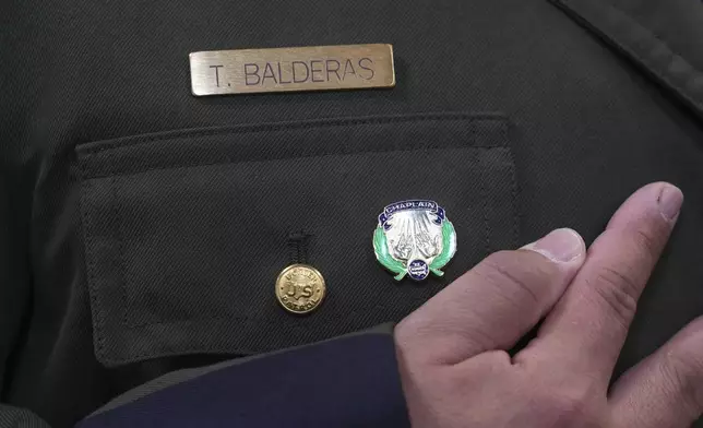 Border Patrol Agent Trinidad Balderas looks at his new chaplain pin after graduating from the program, Thursday, Nov. 21, 2024, in Dania Beach, Fla. (AP Photo/Marta Lavandier)