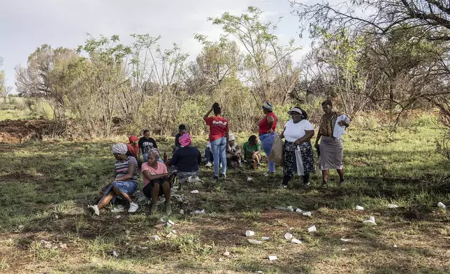 Relatives of miners and community members wait at a mine shaft where an estimated 4000 illegal miners are trapped in a disused mine in Stilfontein, South Africa, Wednesday, Nov.13, 2024. (AP Photo)