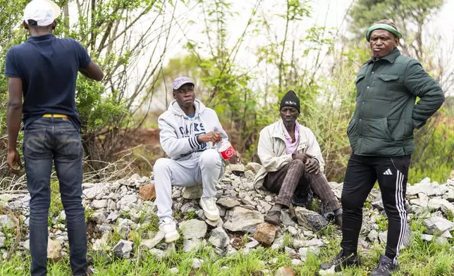 Relatives of miners and community members wait at a mine shaft where illegal miners are trapped in a disused mine in Stilfontein, South Africa, Thursday, Nov. 14, 2024. (AP Photo/Jerome Delay)