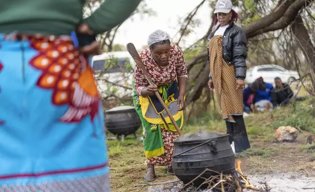 Relatives of miners and community members wait at a mine shaft where illegal miners are trapped in a disused mine in Stilfontein, South Africa, Thursday, Nov. 14, 2024. (AP Photo/Jerome Delay)