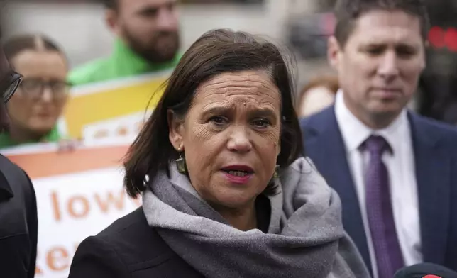 Sinn Fein leader Mary Lou McDonald, center, speaks to the media outside Government Buildings, on the last day of campaigning on the eve of the General Election, in Dublin, Thursday, Nov. 28, 2024. (Brian Lawless/PA via AP)