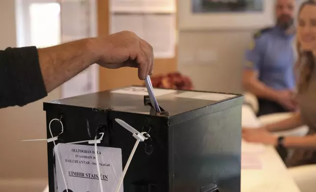 A man casts his vote in a ballot box on the Island of Gola as voters go to polls the for the 2024 General Election in Ireland, Friday, Nov. 29, 2024. (AP Photo/Peter Morrison)