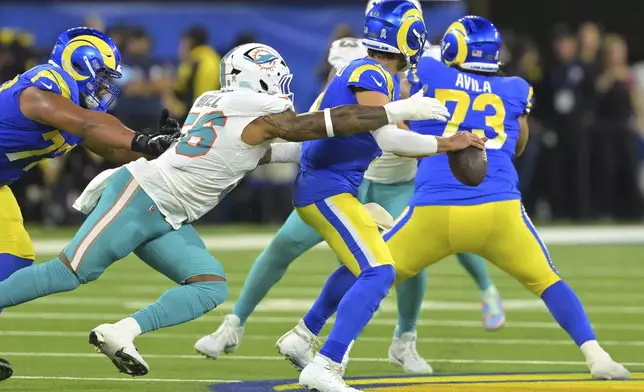 Miami Dolphins linebacker Quinton Bell, left, causes Los Angeles Rams quarterback Matthew Stafford to fumble the ball during the first half of an NFL football game, Monday, Nov. 11, 2024, in Inglewood, Calif. The fumble was recovered by Stafford. (AP Photo/Jayne Kamin-Oncea)