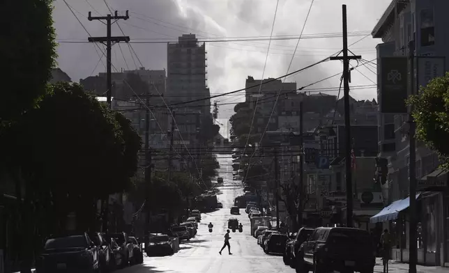 A person crosses a street during a break in rain Saturday, Nov. 23, 2024, in San Francisco. (AP Photo/Andy Bao)