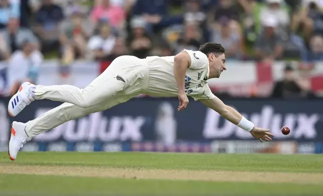 New Zealand's Matt Henry dives to field the ball during play on the second day of the first cricket test between England and New Zealand at Hagley Oval in Christchurch, New Zealand, Friday, Nov. 29, 2024. (John Davidson/Photosport via AP)