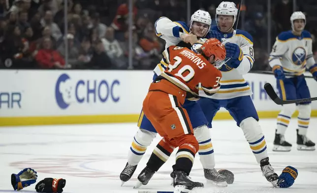 Buffalo Sabres left wing Zach Benson (9) and Anaheim Ducks center Jansen Harkins (38) fight during the second period of an NHL hockey game, Friday, Nov. 22, 2024, in Anaheim, Calif. (AP Photo/Kyusung Gong)