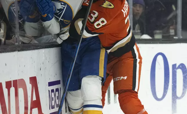 Anaheim Ducks center Jansen Harkins (38) checks Buffalo Sabres defenseman Connor Clifton (75) during the first period of an NHL hockey game, Friday, Nov. 22, 2024, in Anaheim, Calif. (AP Photo/Kyusung Gong)