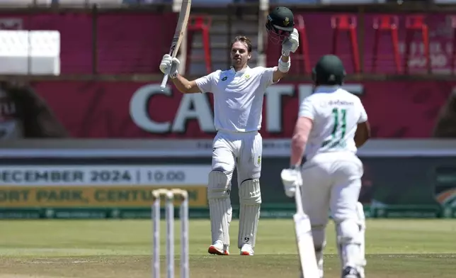 South Africa's Tristan Stubbs raises his bat after reaching his century during the third day of the first Test cricket match between South Africa and Sri Lanka, at Kingsmead stadium in Durban, South Africa, Friday, Nov. 29, 2024. (AP Photo/Themba Hadebe)