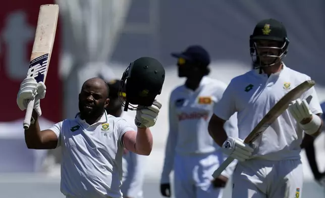 South Africa's captain Temba Bavuma raises his bat after reaching his century during the third day of the first Test cricket match between South Africa and Sri Lanka, at Kingsmead stadium in Durban, South Africa, Friday, Nov. 29, 2024. (AP Photo/Themba Hadebe)